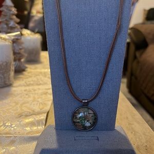 White flower pendant necklace on a brown leather necklace